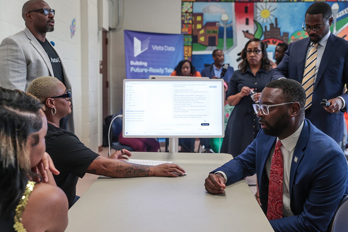 Mayor Paul Young sits with Melrose High School seniors and local senior residents around a computer in the Orange Mound Community Center’s new tech room.
